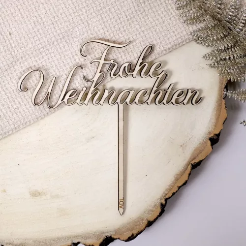 Cake Topper aus Holz mit dem Schriftzug "Frohe Weihnachten" auf dekorierter Holzplatte