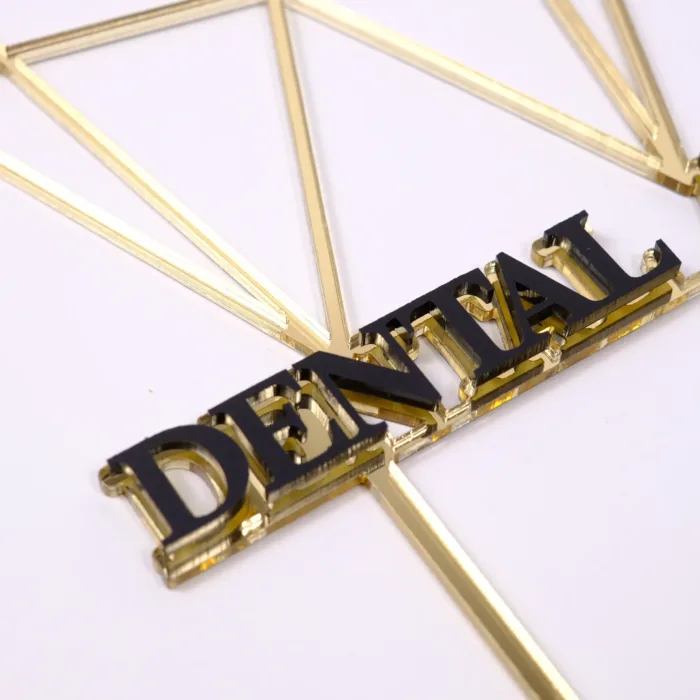 Detailaufnahmen eines Cake Topper in Form eines Zahns mit der Aufschrift DENTAL ART