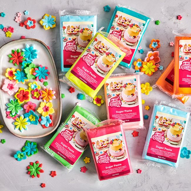 Bunte Auswahl an FunCakes Sugar Paste Fondant in verschiedenen Farben mit dekorativen Zuckerblumen – ideal zum Modellieren und Verzieren von Torten und Cupcakes.