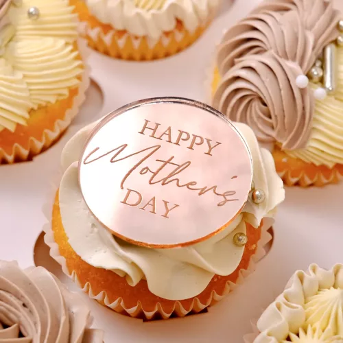 Ein aus Rosegoldener Acryl Aufleger mit der Aufschrift "Happy Mother´s Day" auf einem Cupcake in einer Cupcakebox.