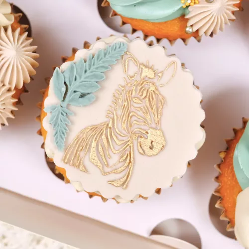 Beiger Keks mit goldenem Zebra-Motiv auf einem Cupcake