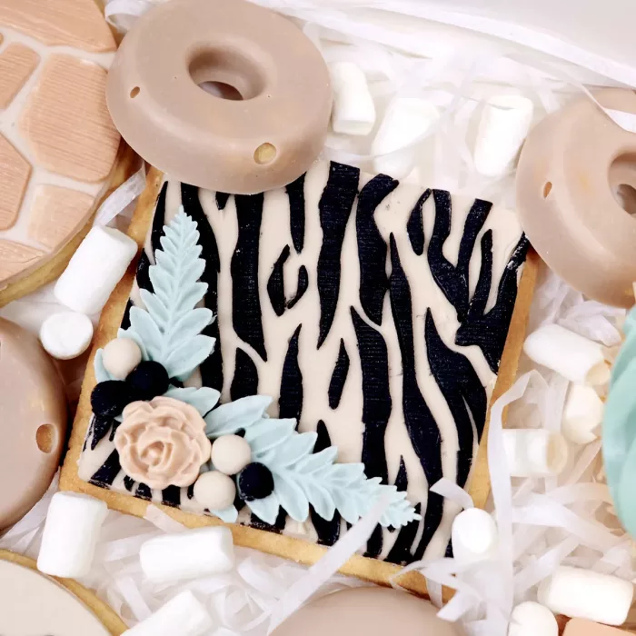 Beiger Keks mit schwarzem Zebrafell-Motiv und einer Blume in der Ecke in einer Sweet Box