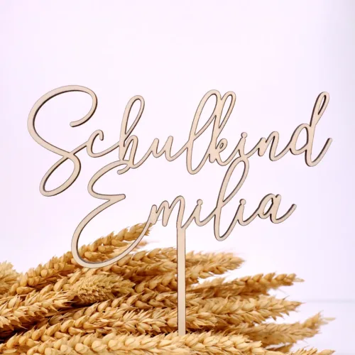 Cake Topper aus Holz mit der Aufschrift "Schulkind Emilia" auf Trockenblumen und weißem Hintergrund