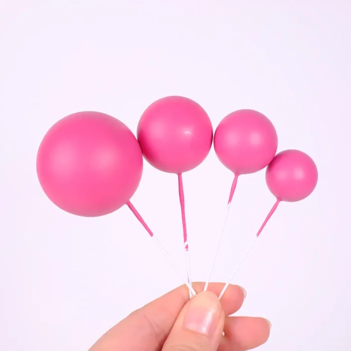 4 pinke Bubbles Einstecker für die Torte in 4 verschiedenen Größen in der Hand