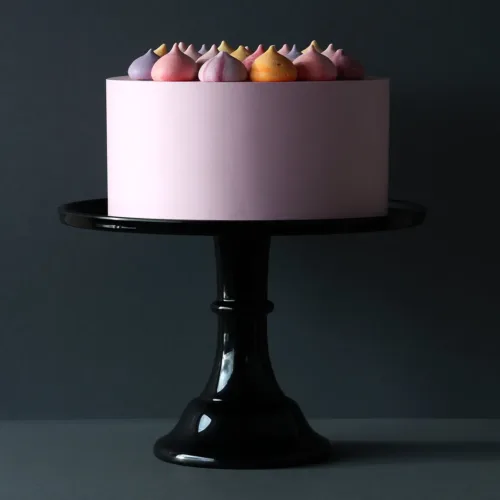 Rosa Torte auf einer großen Tortenplatte der Marke ALLC in Schwarz mit dunklem Hintergrund