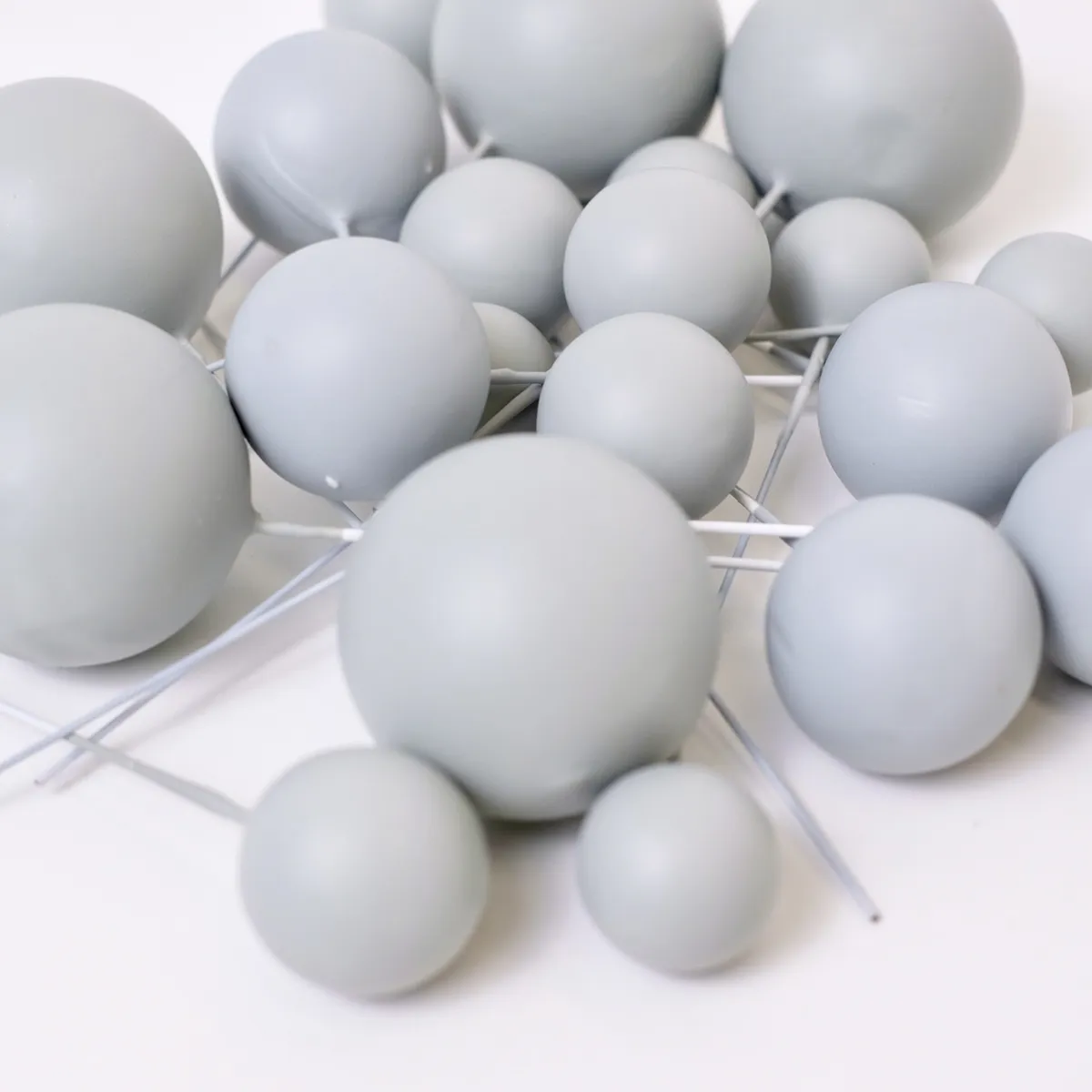 Mehrere matt hellgraue, runde Bubbles Kucheneinstecker in unterschiedlichen Größen