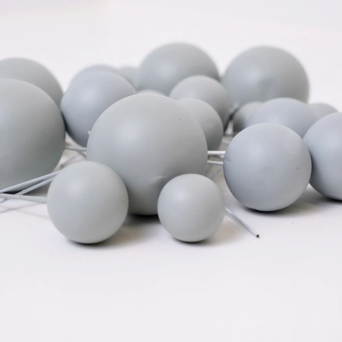 Mehrere matt hellgraue, runde Bubbles Kucheneinstecker in unterschiedlichen Größen