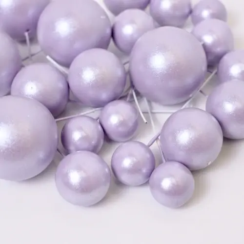 Mehrere glänzend helllilane, runde Bubbles Kucheneinstecker in unterschiedlichen Größen