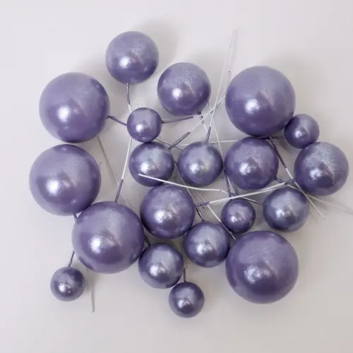 Mehrere glänzend lilane, runde Bubbles Kucheneinstecker in unterschiedlichen Größen