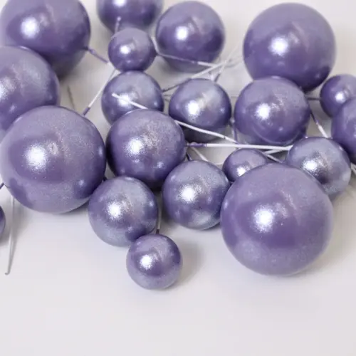 Mehrere glänzend lilane, runde Bubbles Kucheneinstecker in unterschiedlichen Größen