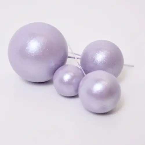 Vier glänzend helllilane, runde Bubbles Kucheneinstecker in unterschiedlichen Größen