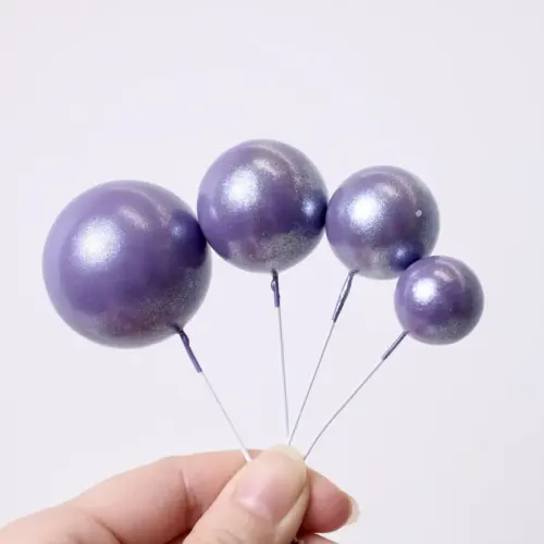 Vier glänzend lilane, runde Bubbles Kucheneinstecker in unterschiedlichen Größen