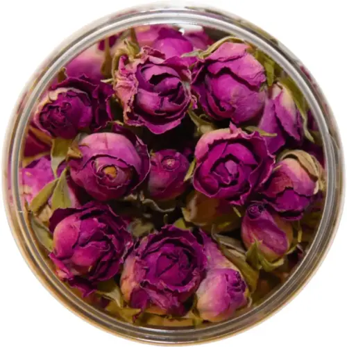 Getrocknete Damaszener-Rosenknospen in Rosa und Violett im offenen Glas zur Dekoration von Torten und Desserts.